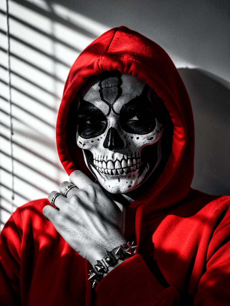 A close-up portrait of a person wearing a vibrant red hooded