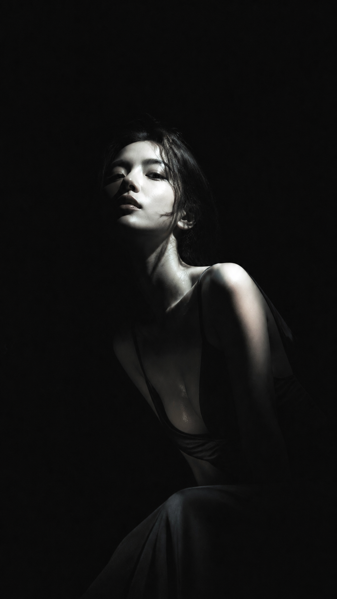 暗黑极简冷光半写实插画,主体为身穿深色低领长裙的漂亮韩国女明星,眼神冷峻,面容俊俏,纯黑背景,大面积黑场吞没画面,侧上方
